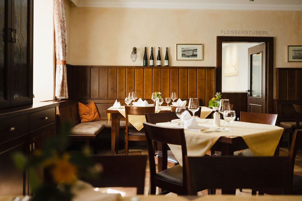 Cozy restaurant with wooden furniture and laid tables.