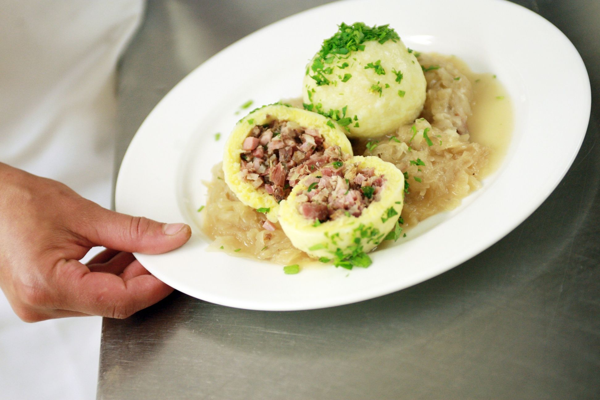 A plate of stuffed dumplings on sauerkraut, garnished with parsley.