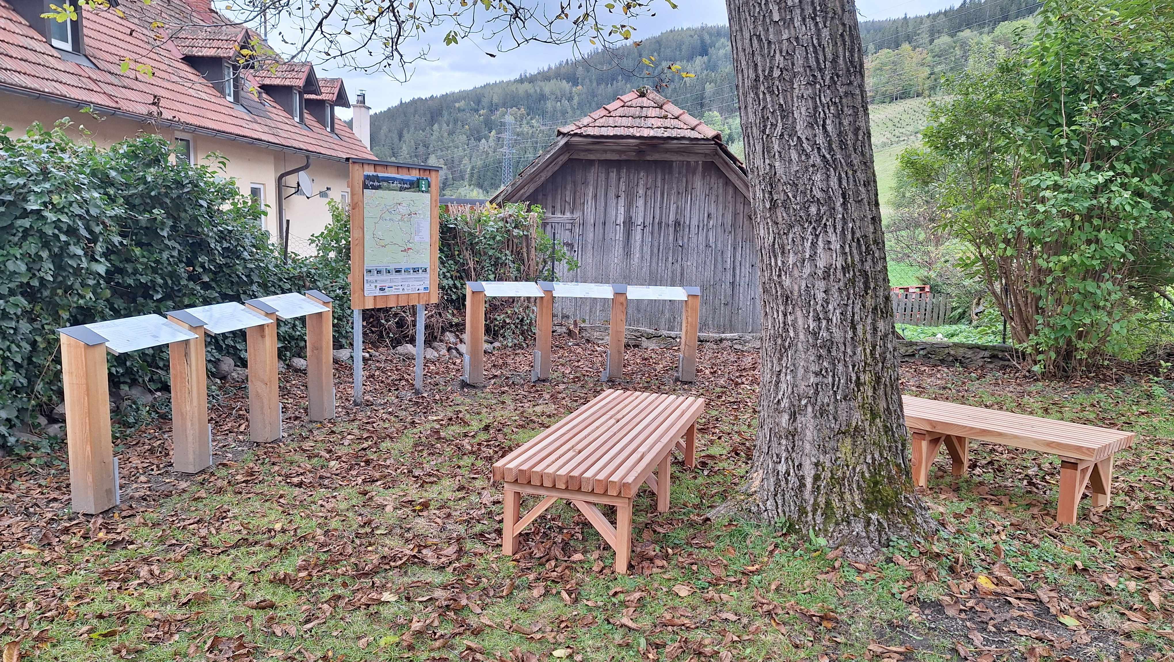 Wooden benches and information boards in the garden of the Wittgensteinhaus.