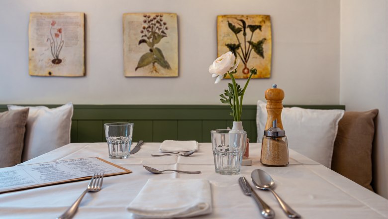 A table set in a restaurant with flowers and spices.