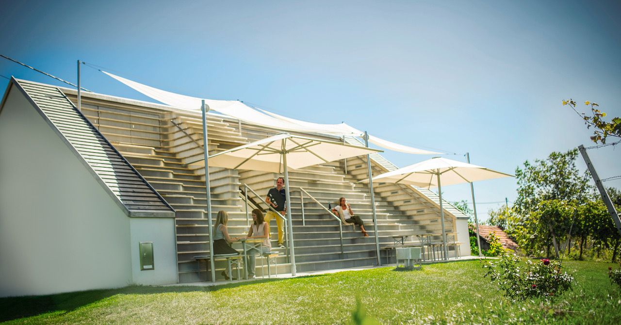 Modern terrace with parasols and people chatting.