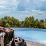 An infinity pool with trees in the background and a bicycle helmet in the foreground.