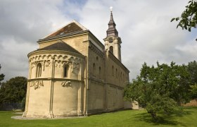 Romanesque church in Grabern with tower and green meadow.