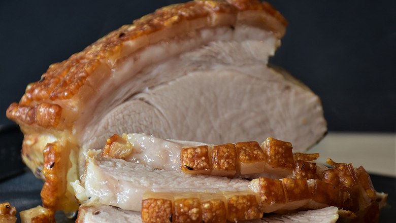A pork roast with a crispy crust, cut into slices.
