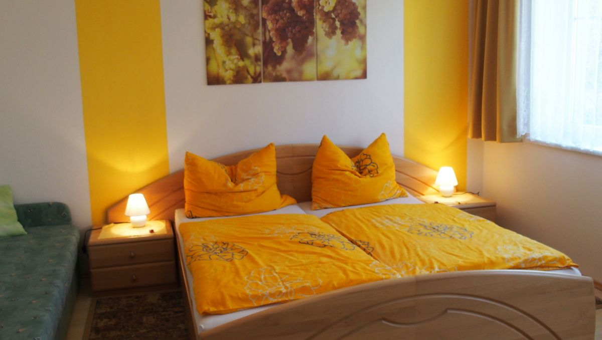 Cozy bedroom with yellow bed linen and warm light.