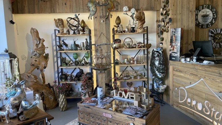 Interior view of a decoration store with wooden shelves and various decorative items.