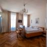 Elegant hotel room with double bed, parquet floor and chandelier.