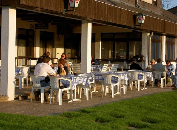 People sitting at outdoor tables in front of a building.