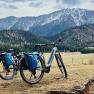 Two mountain bikes with blue bags in front of a mountain landscape in the Schneebergland.