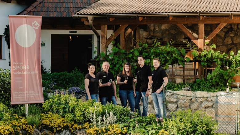 Group of five people in front of a winery with a Sporr banner.