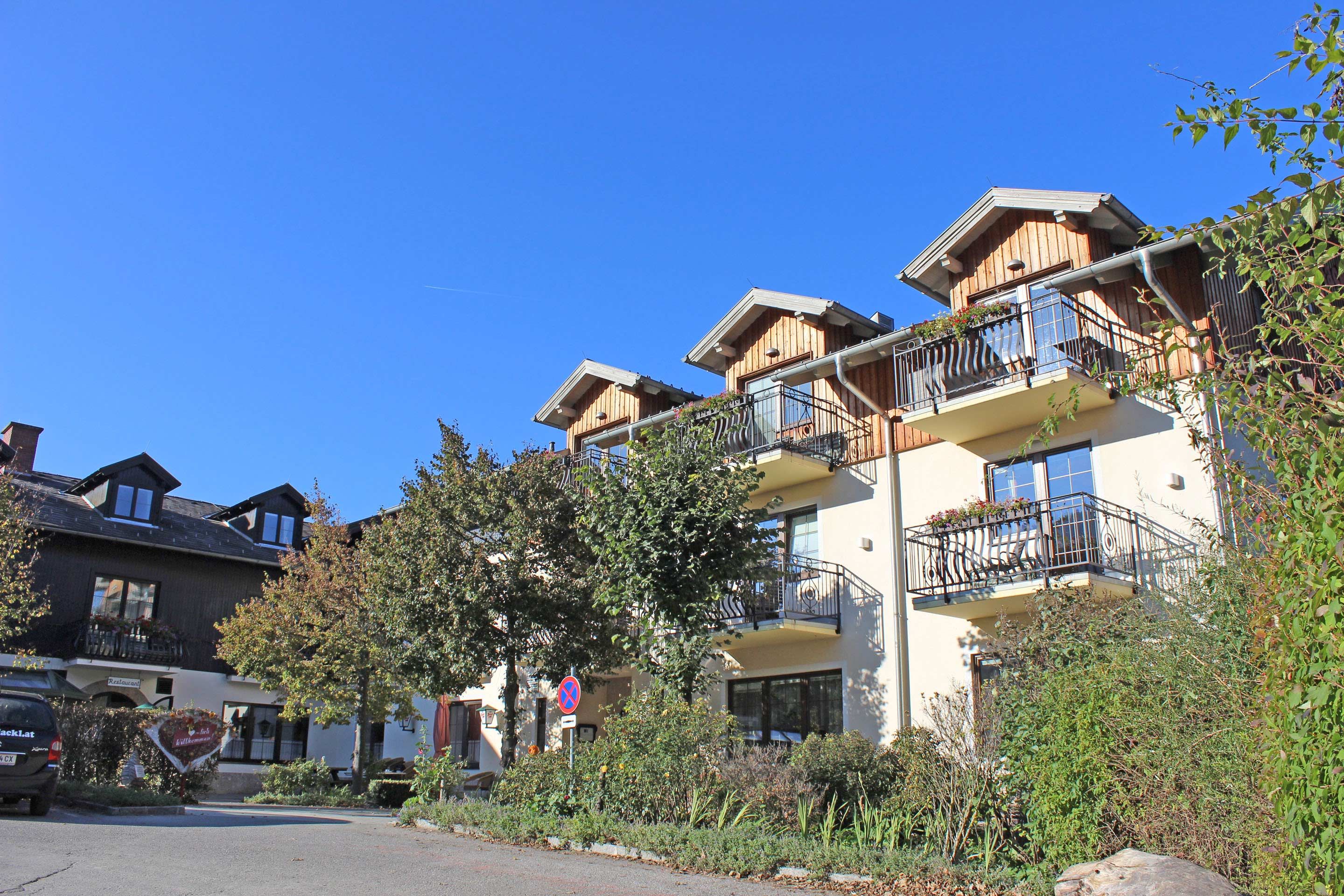 Exterior view of a building with balconies and a blue sky.