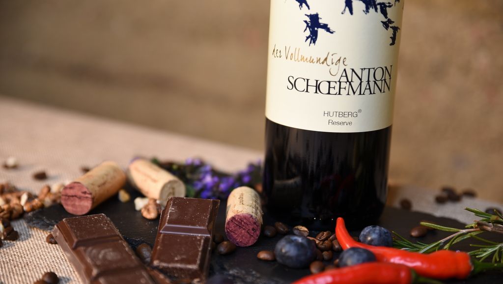 Wine bottle with chocolate, cork and spices on a table.