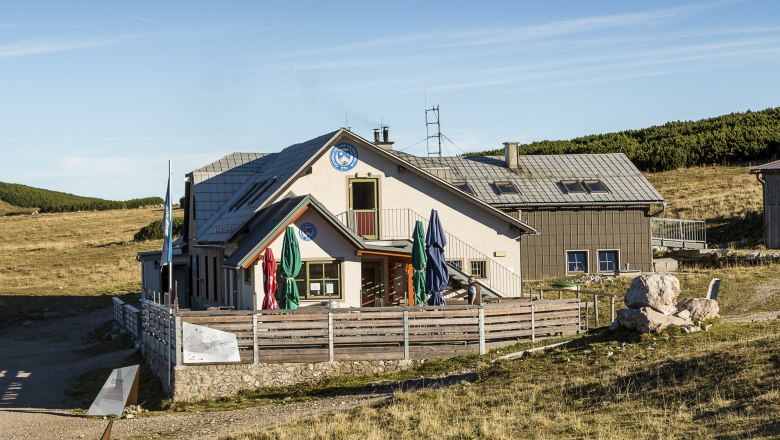 The Damböckhaus on the Schneeberg in a sunny mountain landscape with a blue sky.