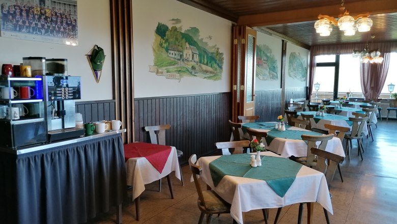 Interior view of a restaurant with wooden furniture and tablecloths.