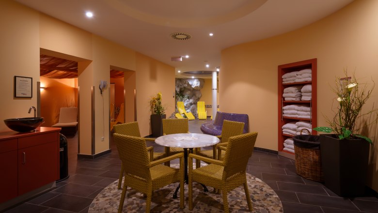 Wellness area of a hotel with table, chairs and loungers.