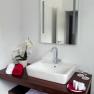 Modern bathroom with washbasin, mirror, towels and orchid.