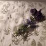 A bouquet of lavender lies on a cushion with a plant pattern.