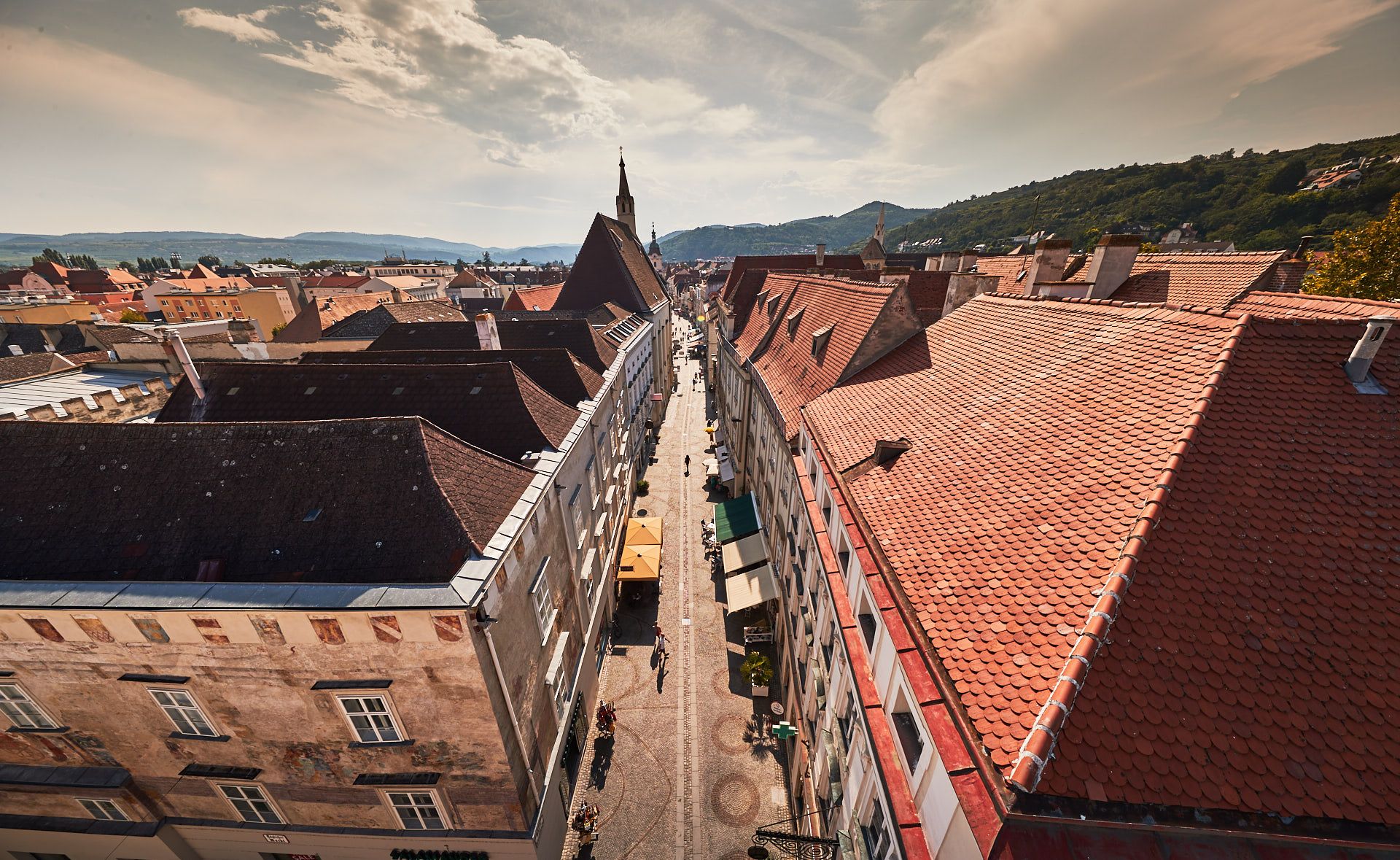 Aerial view of the old town of Krems with red tiled roofs and a central street.