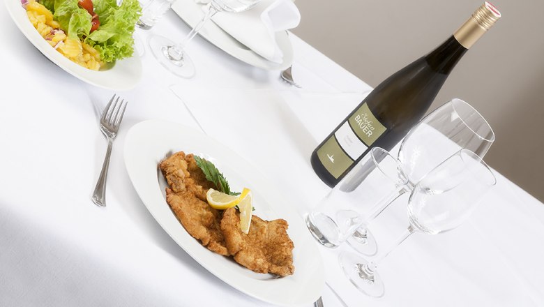 Landgasthof Mann Königsbrunn Dining, © Landgasthof Mann Königsbrunn Table set with schnitzel, salad and bottle of wine.