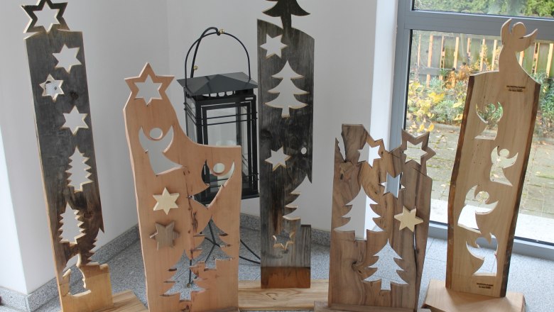 Wooden decorations with stars and angels in front of a window.