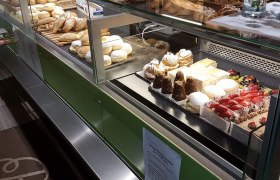 A bakery counter with various baked goods and cakes.