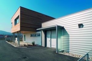 Modern building with wooden and metal façade, clear sky.