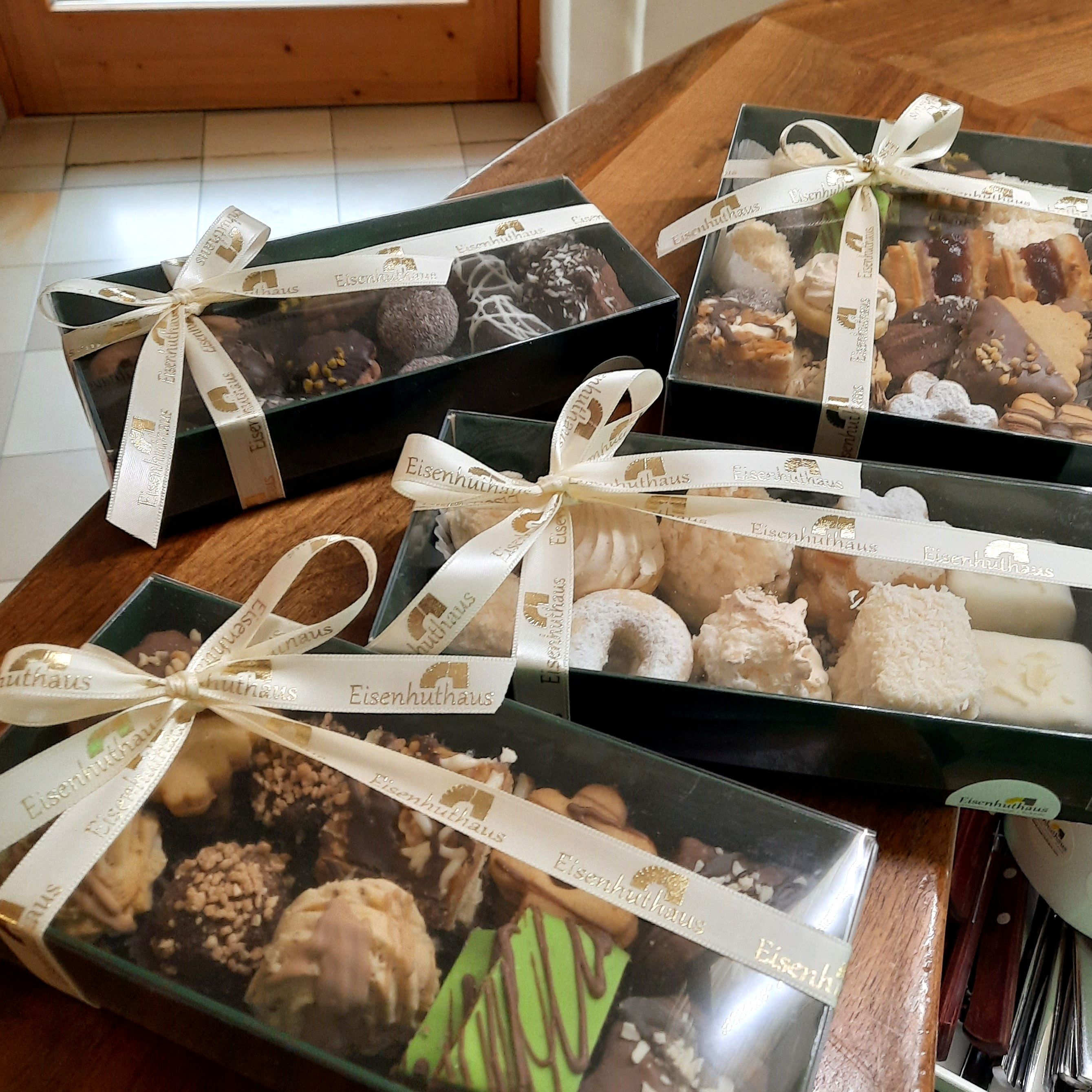 Gift boxes with Christmas cookies on a table.