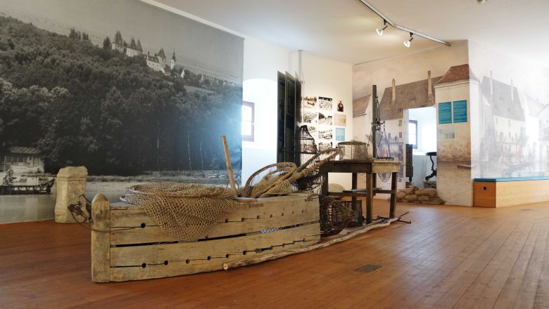 Interior view of a museum with historical fishing gear and murals.