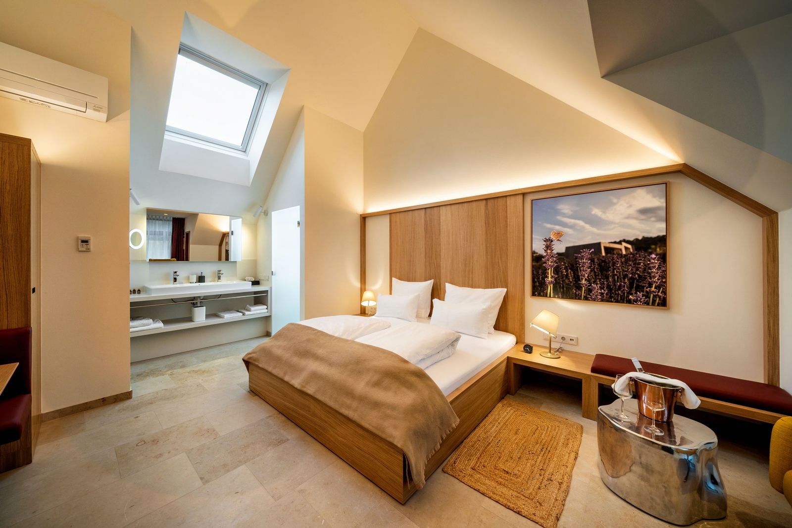 Modern hotel room with skylight, double bed and stylish furnishings.