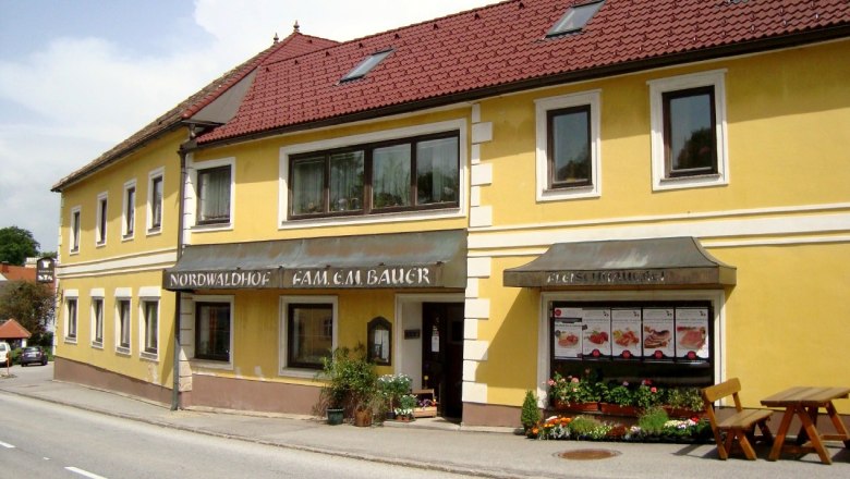 Yellow building with red roof and signs 'Nordwaldhof' and 'Fleischhauerei'.