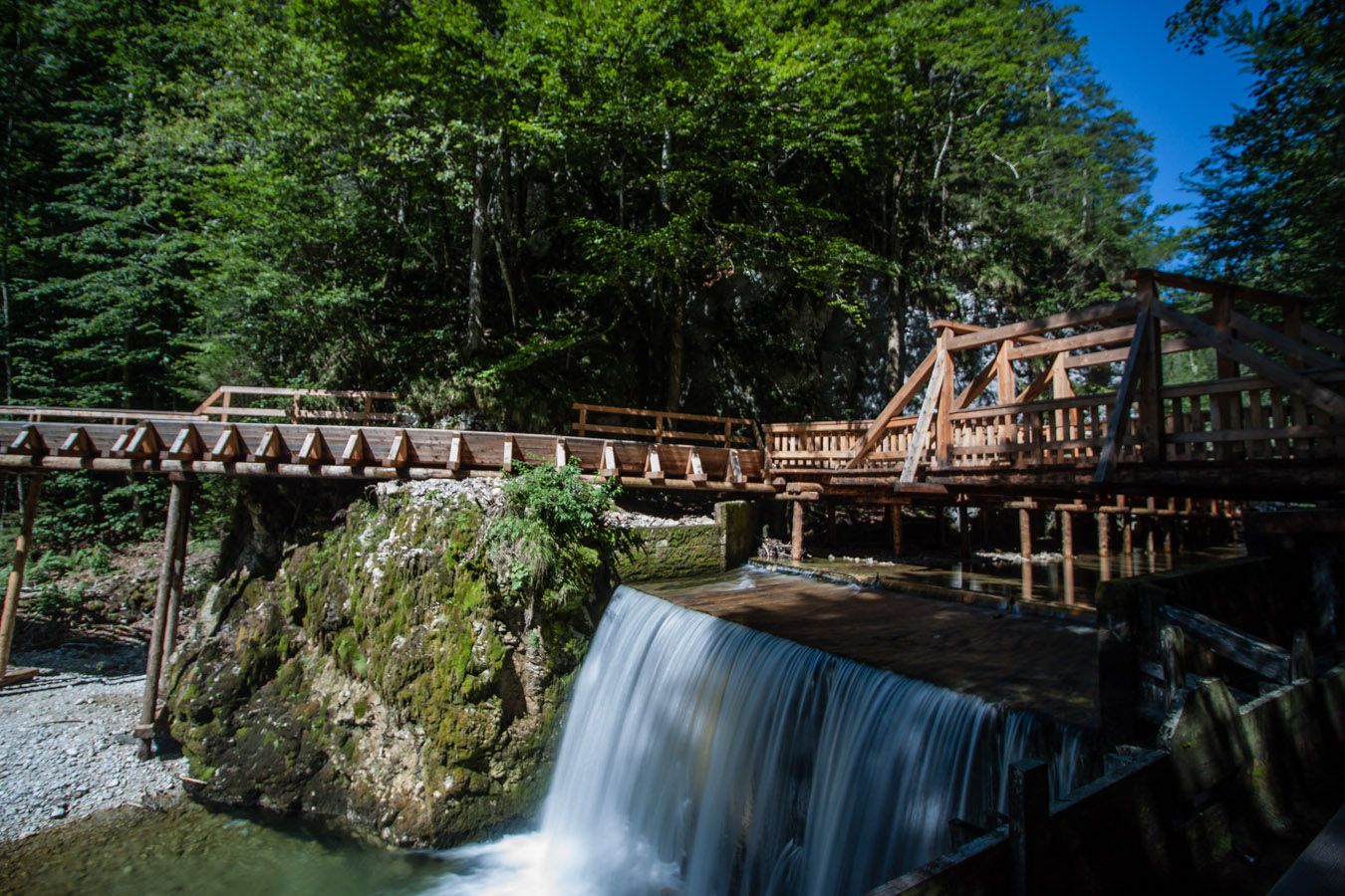 Wooden bridge over a small waterfall in the Mendlingtal valley.