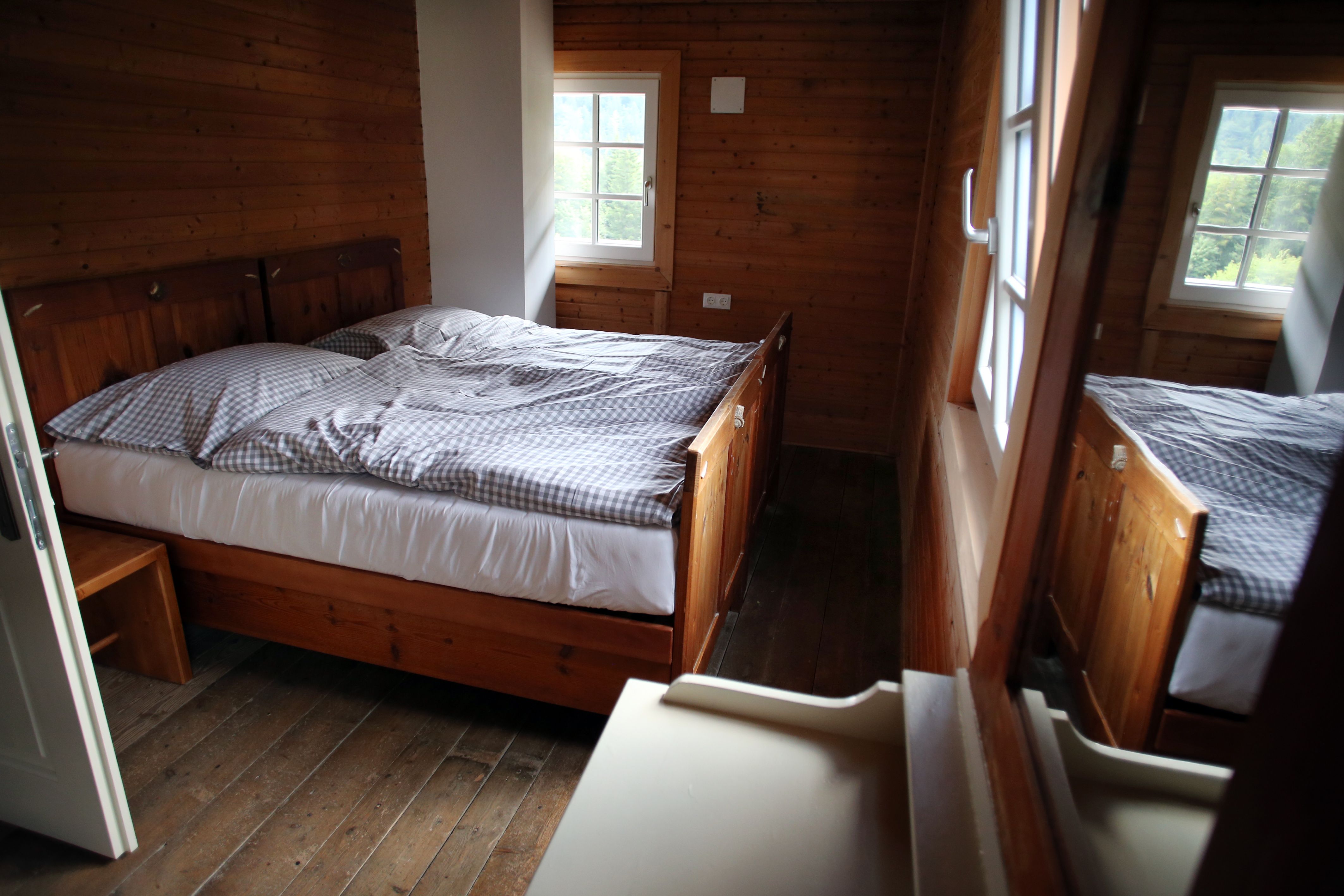A cozy room with wooden walls and a double bed in the Vorderötscher shelter.