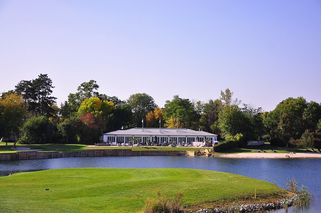 Building on the lake in the Diamond Country Club surrounded by trees.
