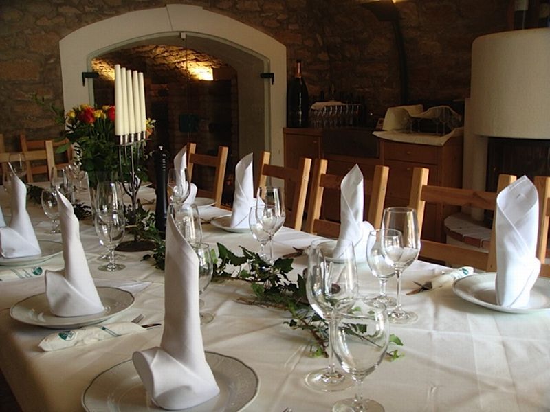 Elegant table with white napkins and wine glasses in a rustic room.