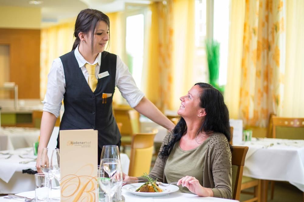 A waitress serves a woman in a restaurant.
