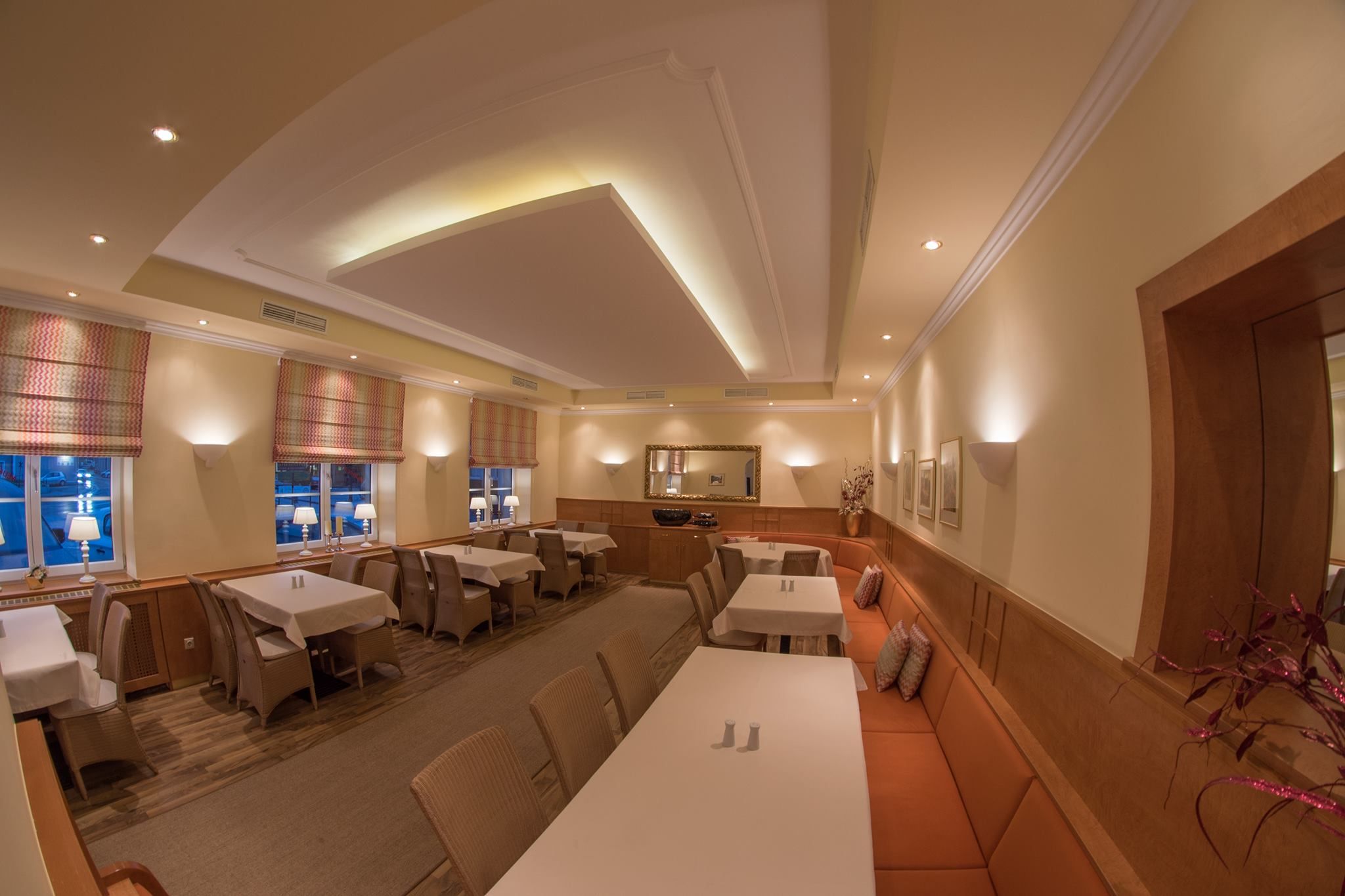 Elegant restaurant with laid tables, warm lighting and stylish decoration.
