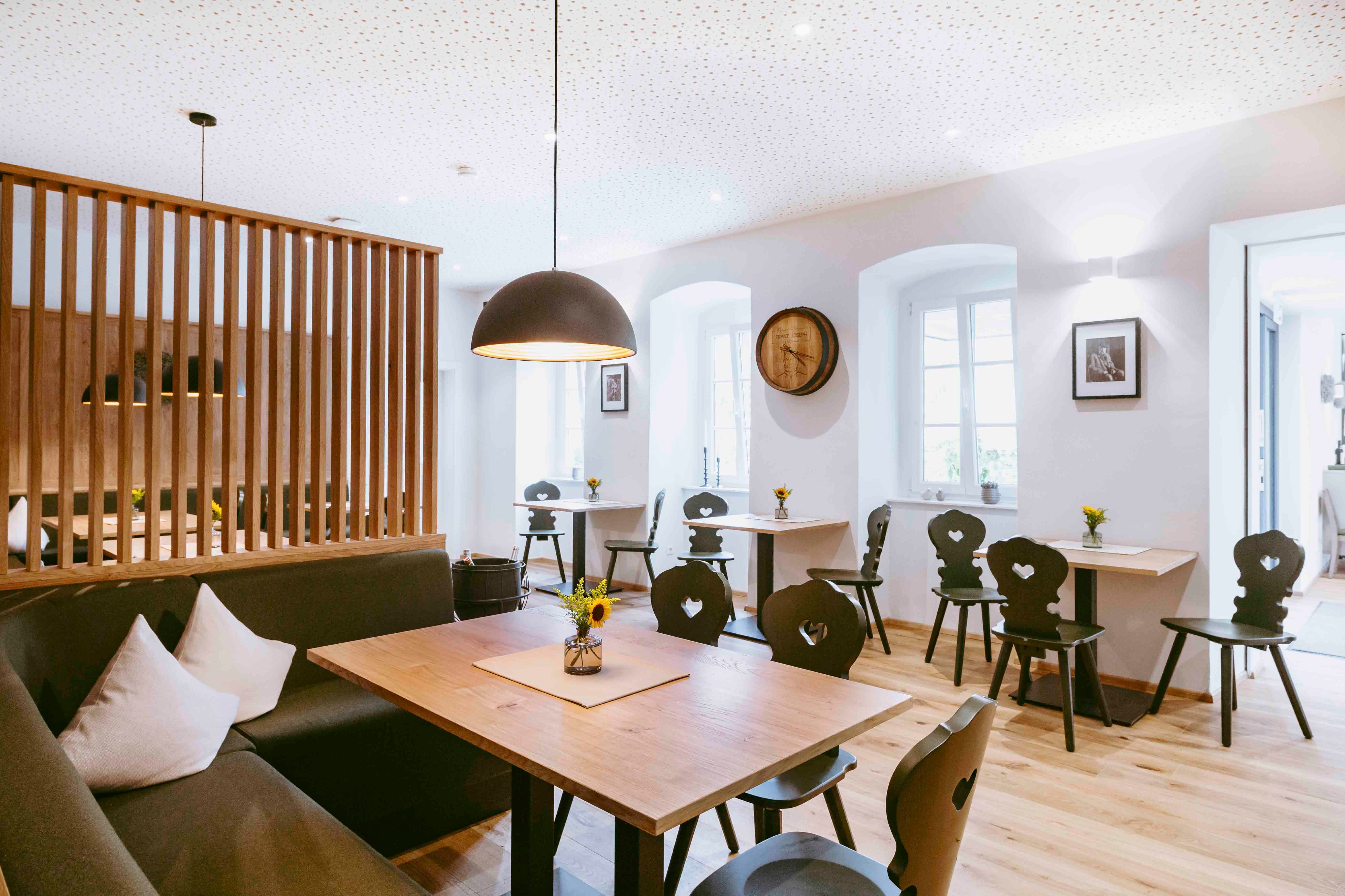 Modern dining room with wooden furniture and stylish lighting.