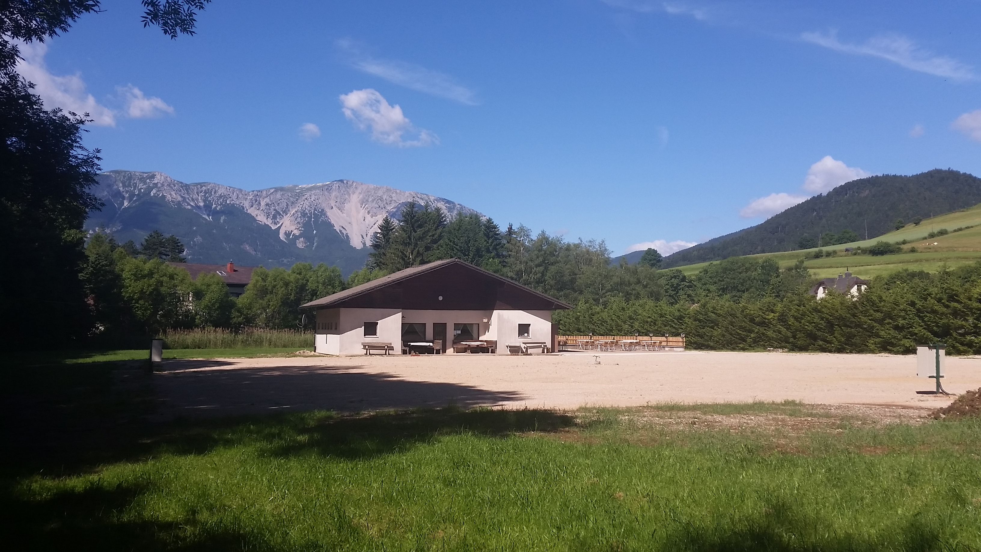 A building on a campsite with a view of a mountain in the background.
