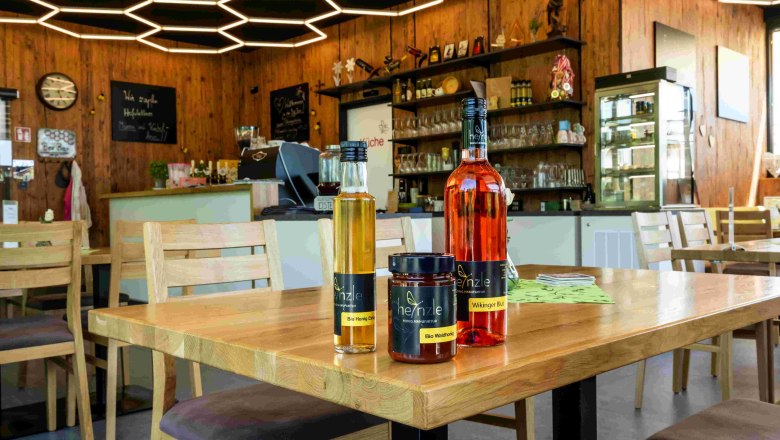 Interior view of a bar with honey-shaped ceiling lighting and honey products on a table.