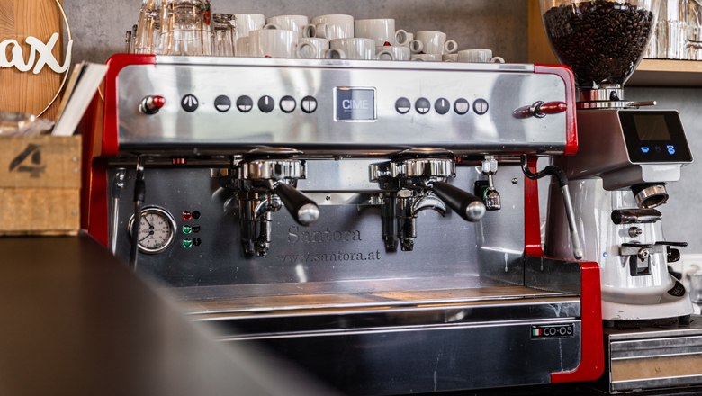 Professional espresso machine with cups and coffee grinder.