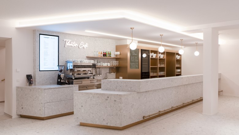 Modern theater café in the Stadttheater Wiener Neustadt with a bright stone look, stylish lamps and an inviting bar