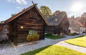 Traditional wooden houses in the Krumbach museum village in the sunshine.