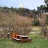 Picnic table on a meadow with trees and a large white radome in the background.