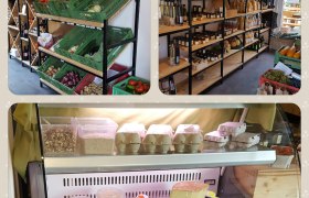 Interior view of a farm store with shelves full of vegetables, jams, eggs and dairy products.