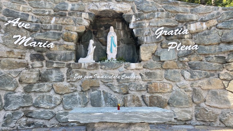 Stone grotto with statue of the Virgin Mary and inscription 'Ave Maria'.