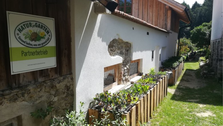 Exterior view of a building with sign 'Natur im Garten Partnerbetrieb'.