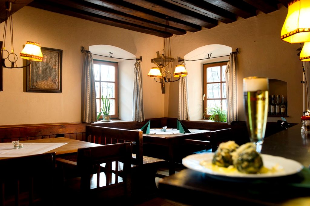 Cozy restaurant with wooden furniture, beer and dumplings on a table.
