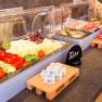 Buffet with cheese, cold cuts, vegetables and bread.