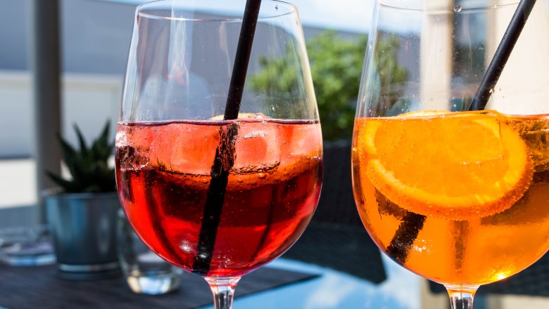 Wine glasses filled with red and yellow drink