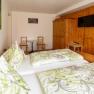 Comfortable guest room with double bed, wooden furniture and TV.